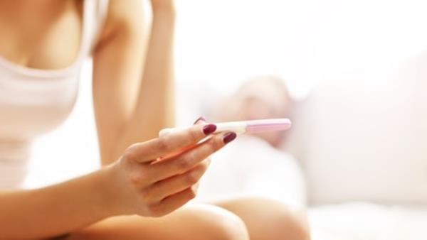 woman checks pregnancy test to see result