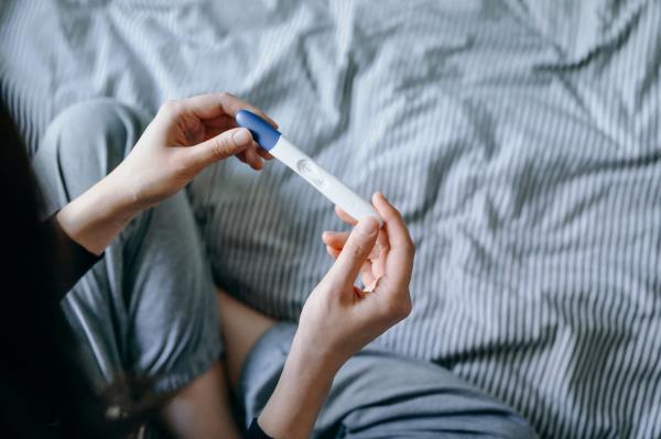 An image of a woman holding a negative pregnancy test.
