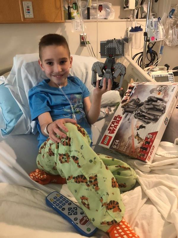 Noah McFall Holding Star Wars Legos in Hospital Bed
