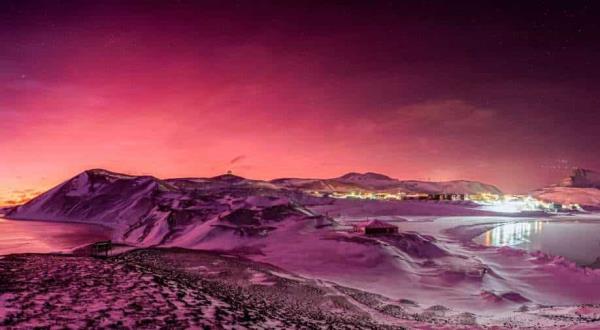 南极洲在明亮的淡紫色和橙色的夜空中闪耀;汤加火山喷发7个月后