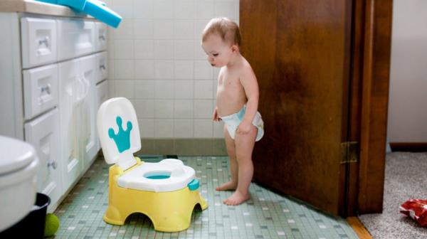 diapered baby in bathroom during potty training