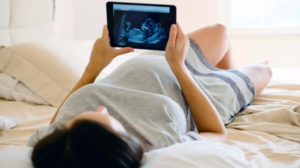 pregnant person looks at ultrasound picture
