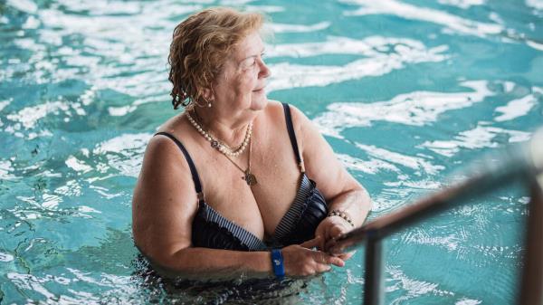 Senior woman standing in a pool.