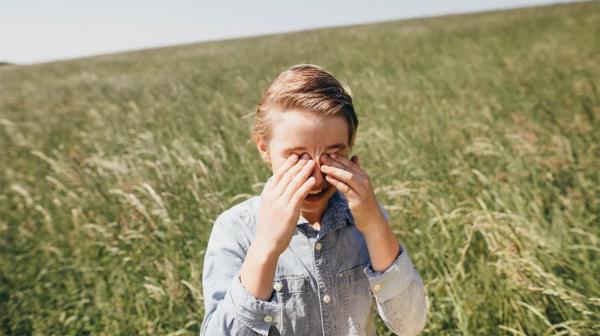 child with hay fever rubbing their eyes
